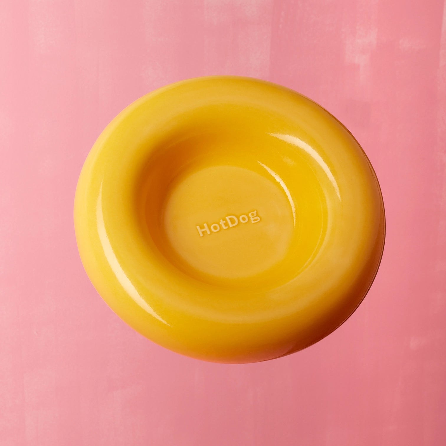 Yellow bowl with 'HotDog' text on a pink background