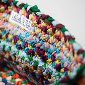 Close-up of a colorful braided rug with a white background