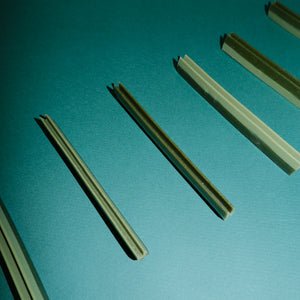Green dog chew dental strips on a teal background