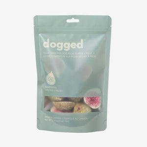 Package of 'dogged' pet food with figs on a light gray background