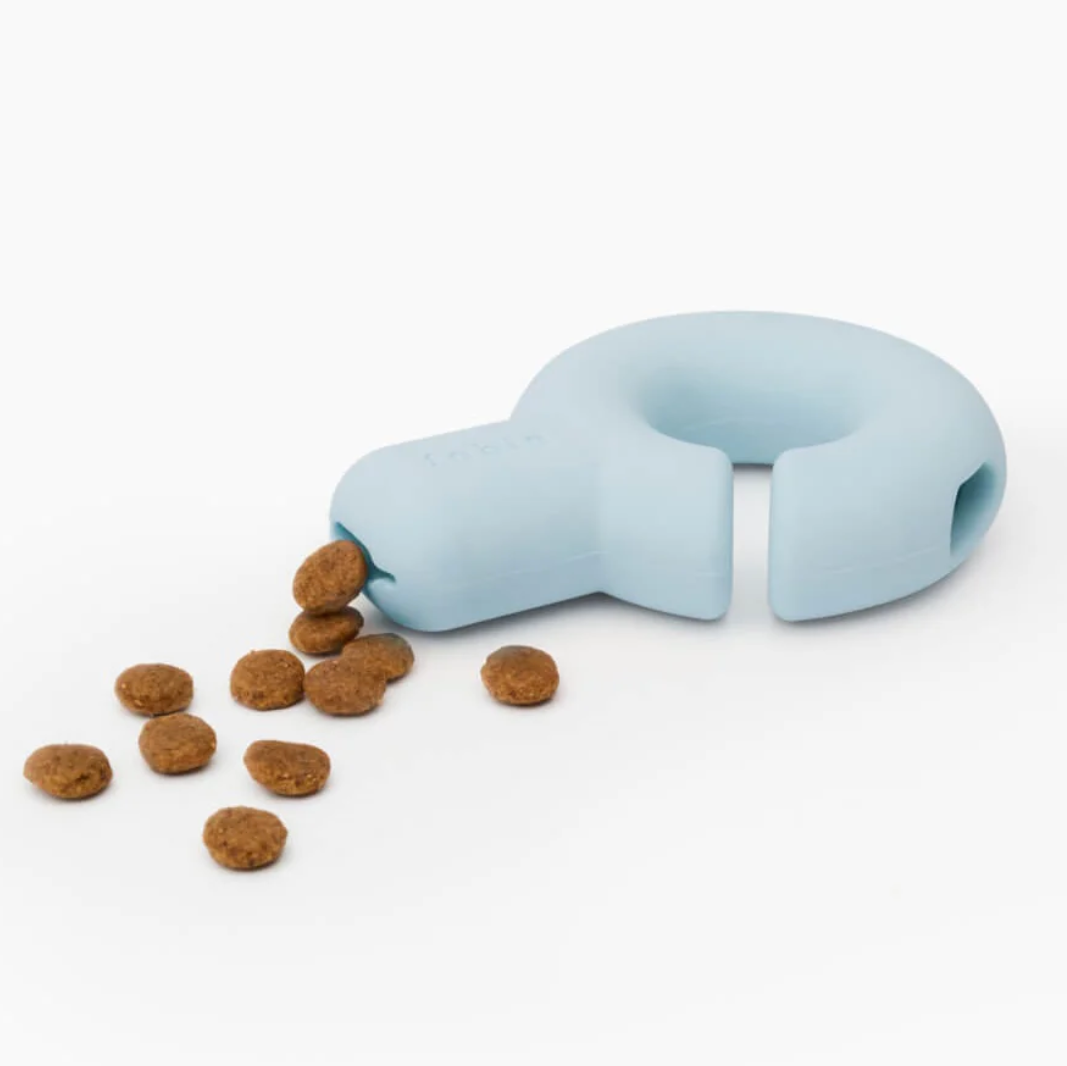 Blue pet toy with kibble on a white background