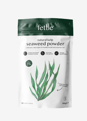 A bag of Fettle natural kelp seaweed powder with a green plant illustration, next to a small bowl of the powder.