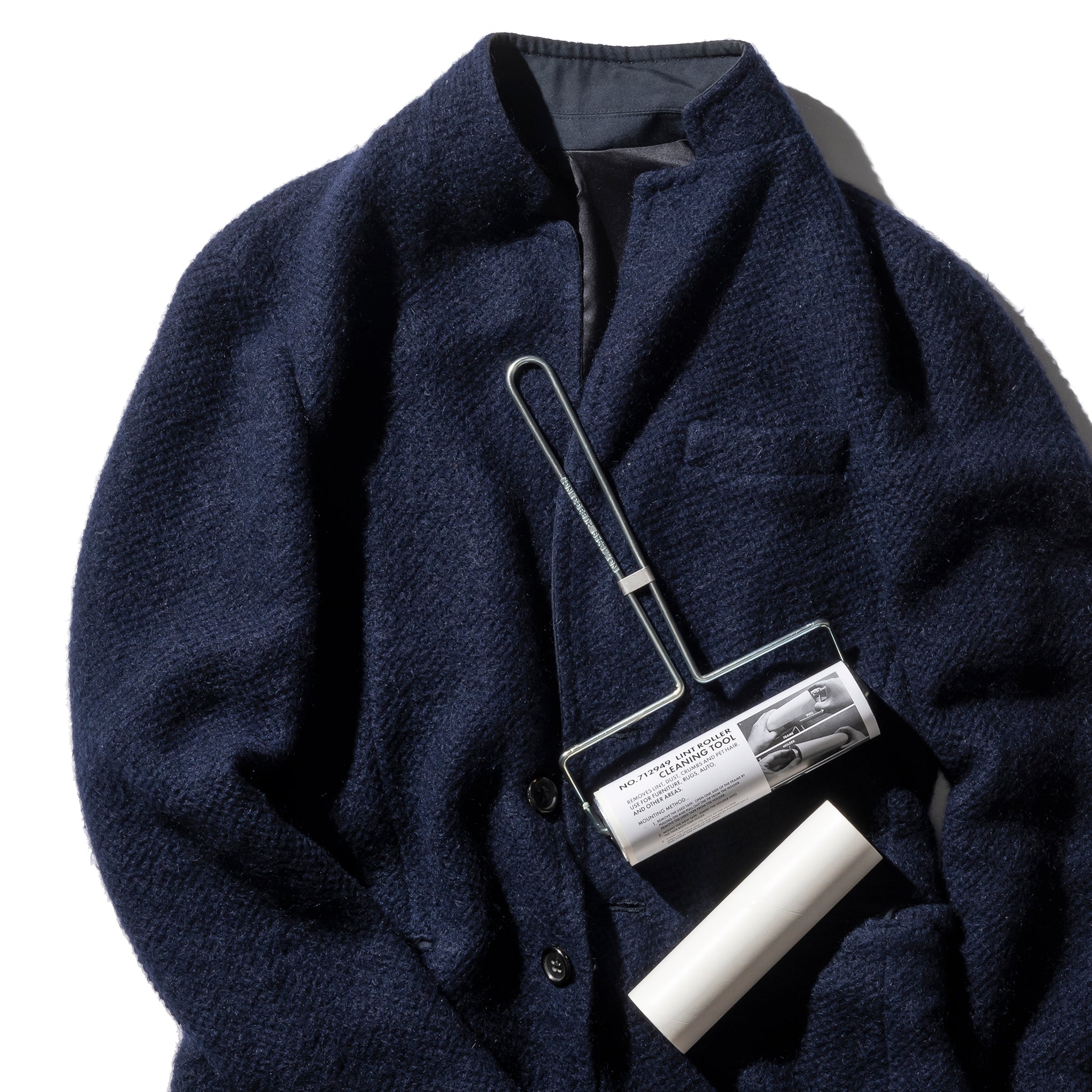 Navy blue coat with a cleaning tool on a white background
