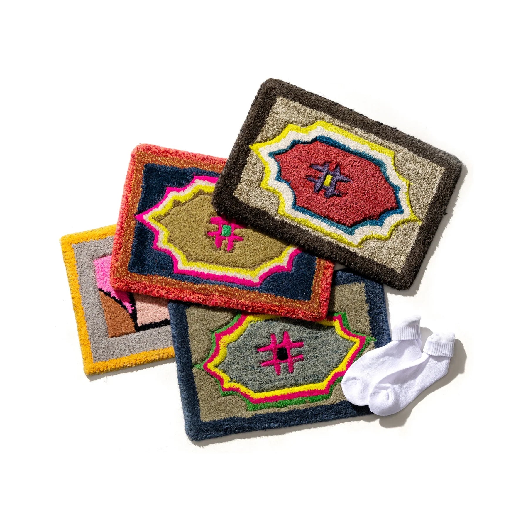 Colorful embroidered rugs with geometric patterns on a white background