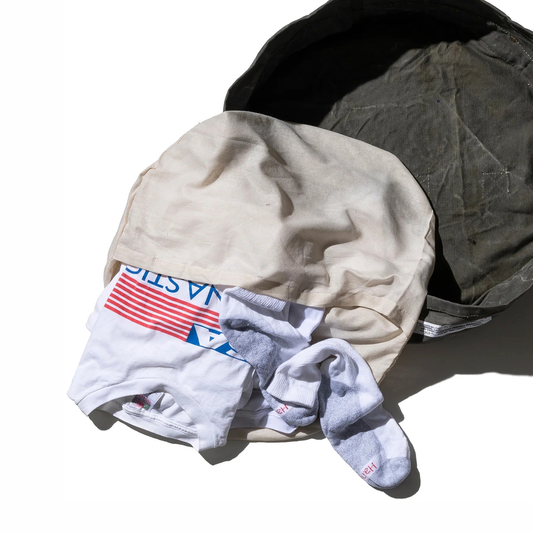 Stack of folded clothes including a shirt, pants, and socks on a white background
