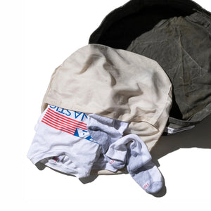 Stack of folded clothes including a shirt, pants, and socks on a white background