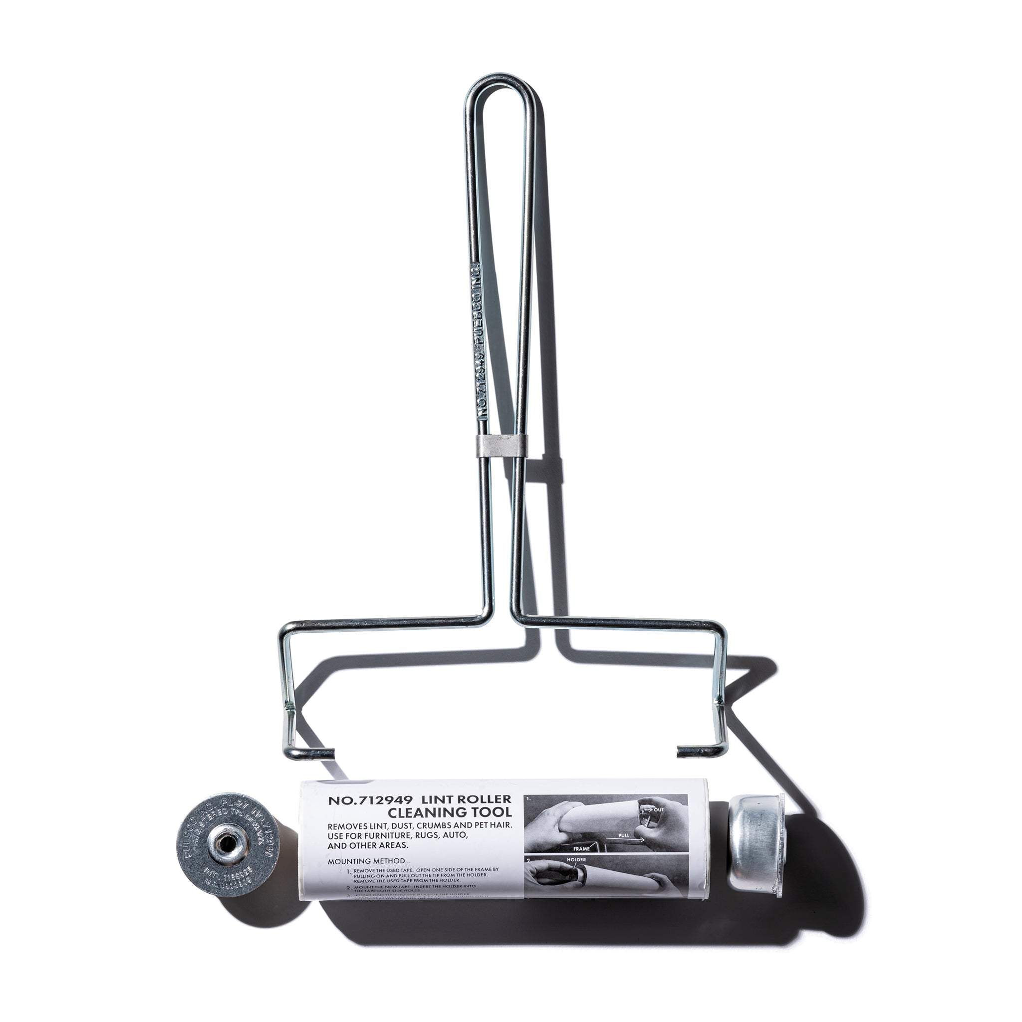 Cleaning tool for furniture with a cylindrical roller and handle on a white background