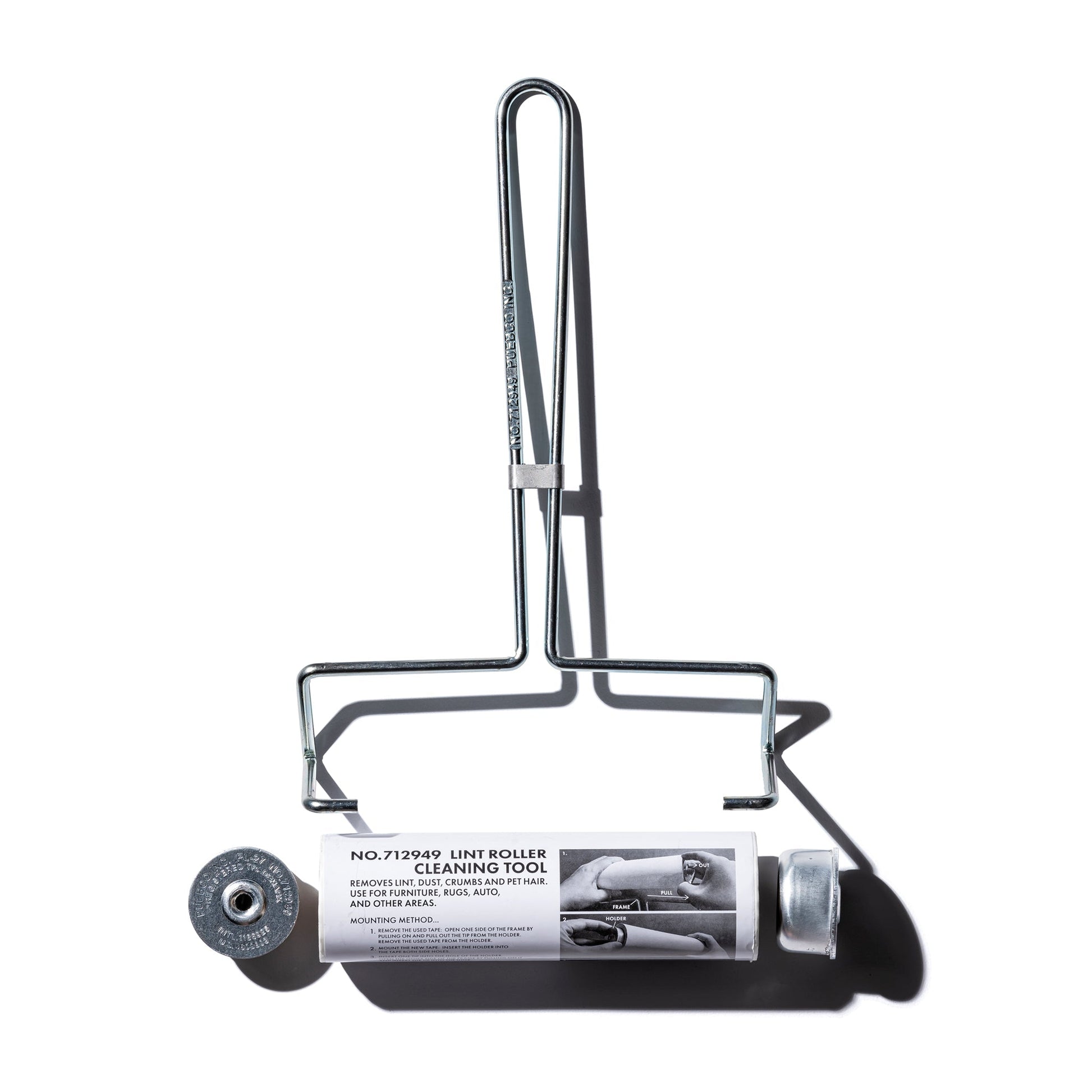 Cleaning tool for furniture with a cylindrical roller and handle on a white background