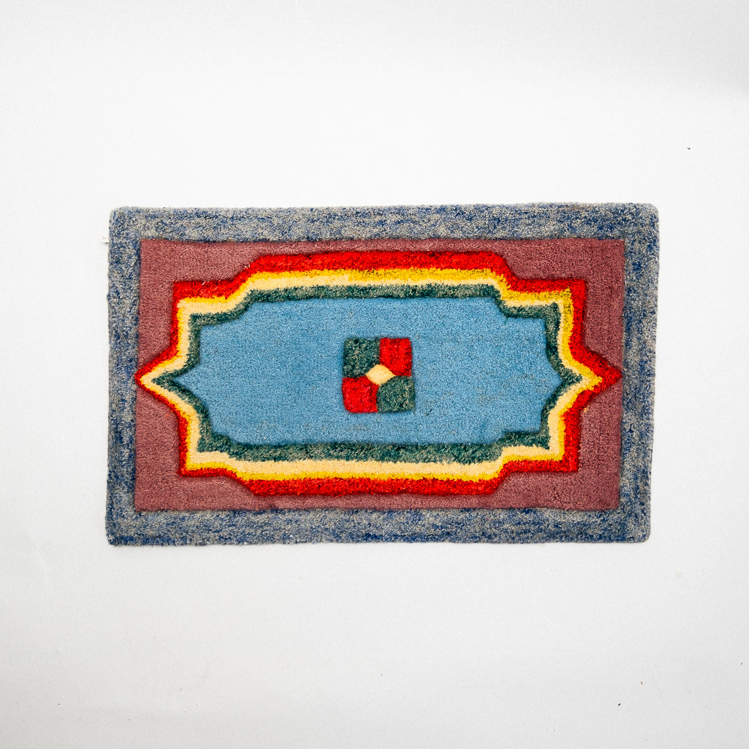 Rectangular doormat with a colorful geometric pattern on a white background