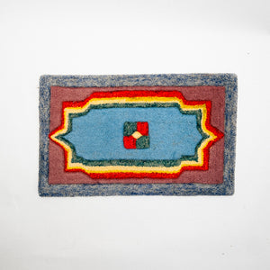 Rectangular doormat with a colorful geometric pattern on a white background