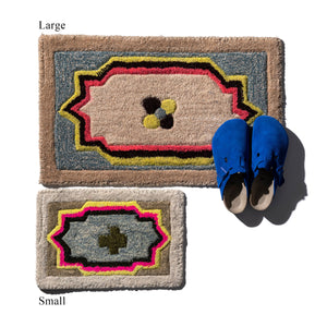Two decorative mats, one large and one small, with a pair of blue shoes on top.