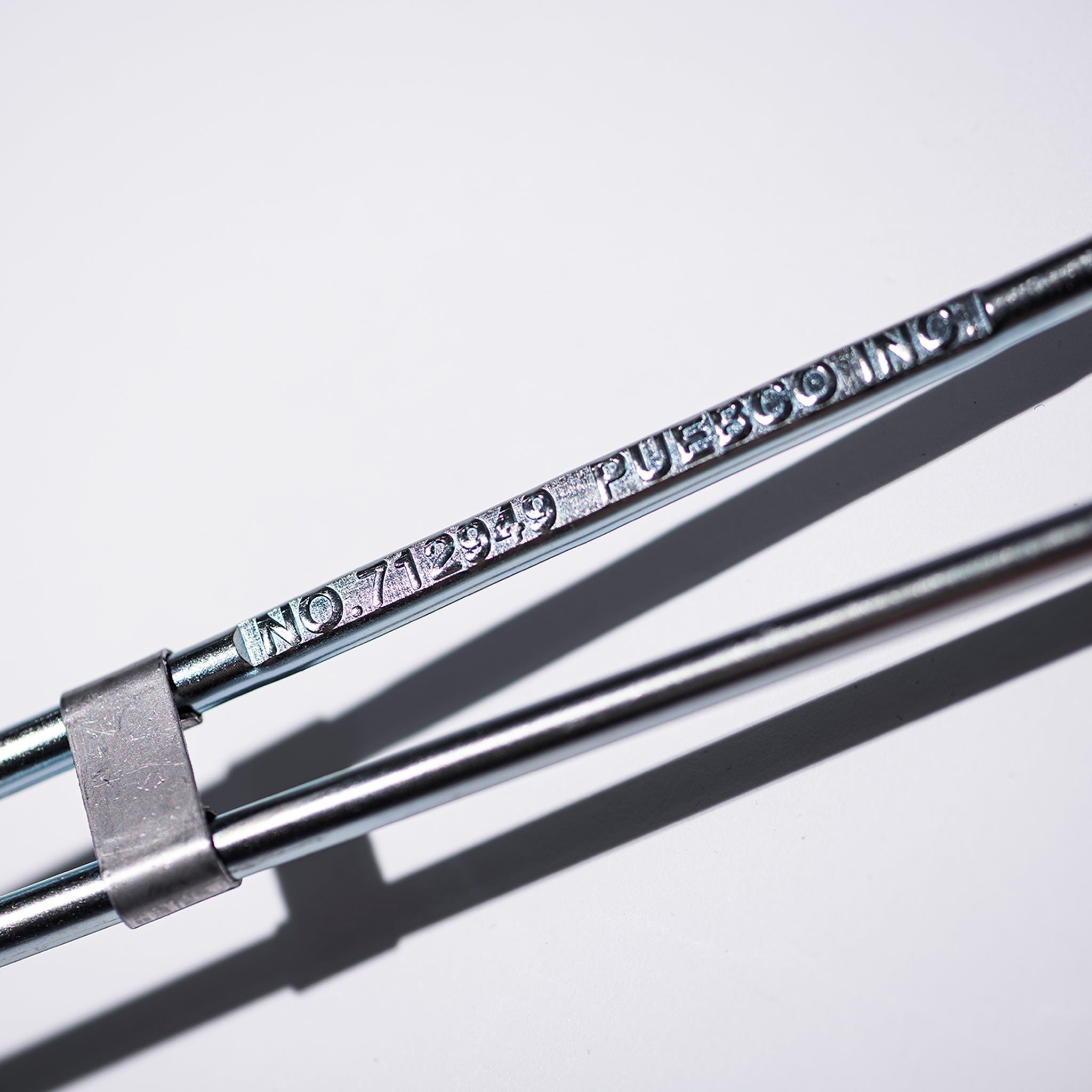 Metal rod with engraved text on a white background
