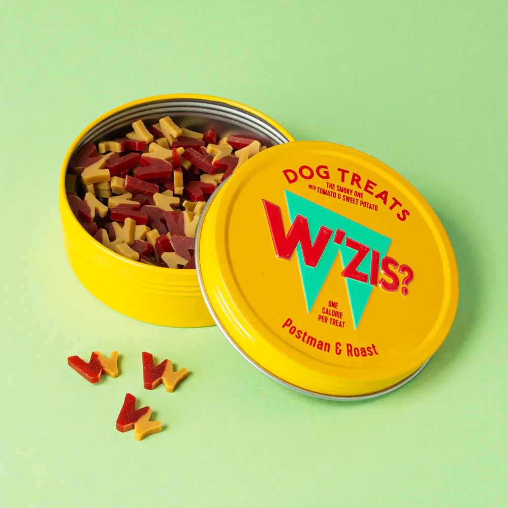 Yellow circular tin, with the lid open showing dog treats with tomato and sweet potato.